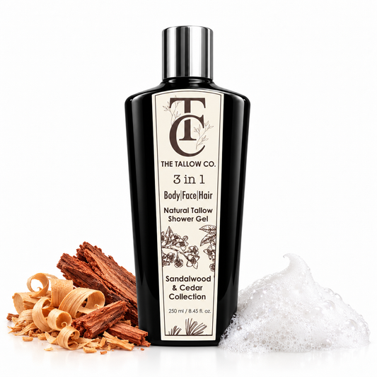A bottle of The Tallow Co. 3 in 1 Body/face/Hair shower gel stands on a white background with sandalwood pieces, curled wood shavings, and foam around it.