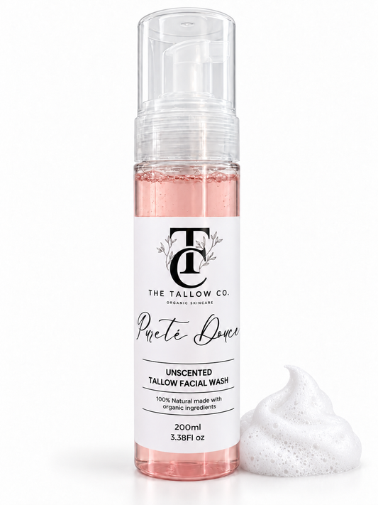 A 200ml bottle of The Tallow Co. Pretend Face Unscented Facial Wash with a clear pump and a white label, shown next to a dollop of white foam on a white background.